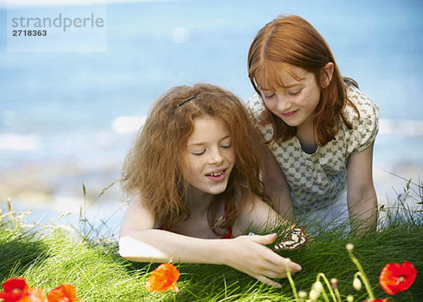 2 Mädchen beobachten Schmetterling