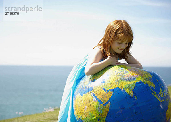 Junges Mädchen schaut auf den aufblasbaren Globus