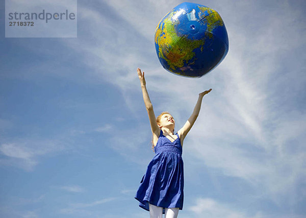 Junges Mädchen wirft aufblasbaren Globus