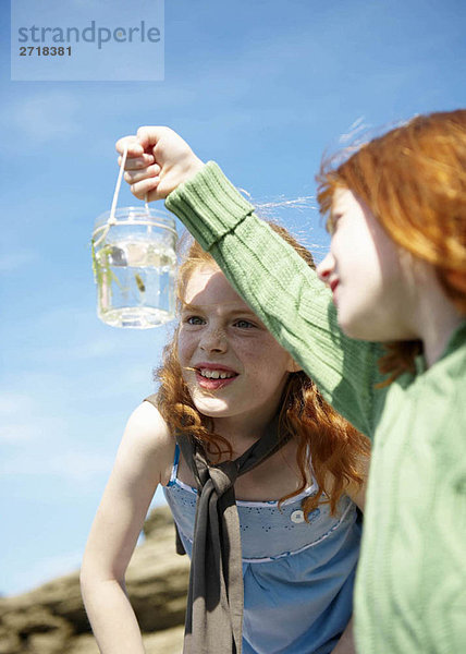 2 Mädchen schauen Fische im Glas an
