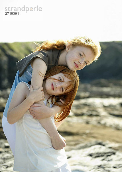 Mädchen umarmt ihre kleine Schwester