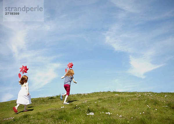 2 Mädchen im Feld mit Windmühlen