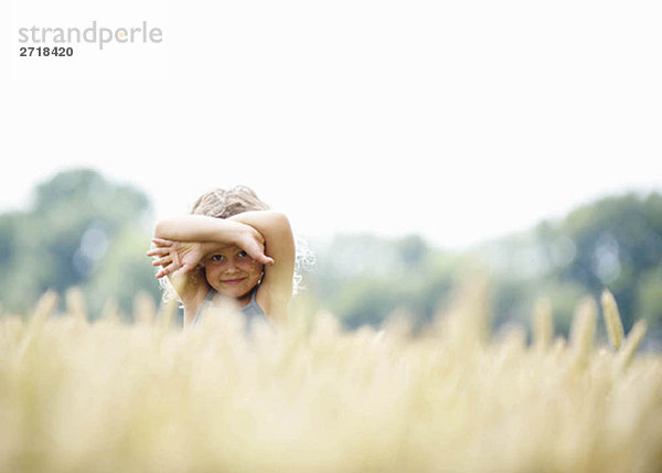 Junges Mädchen versteckt sich im Maisfeld