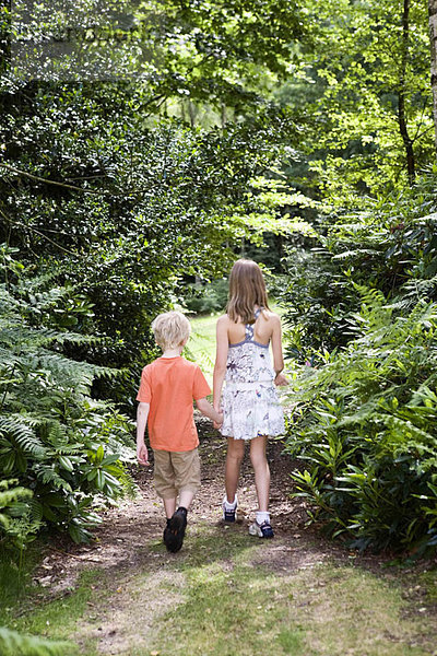 Junge und Mädchen gehen durch den Wald