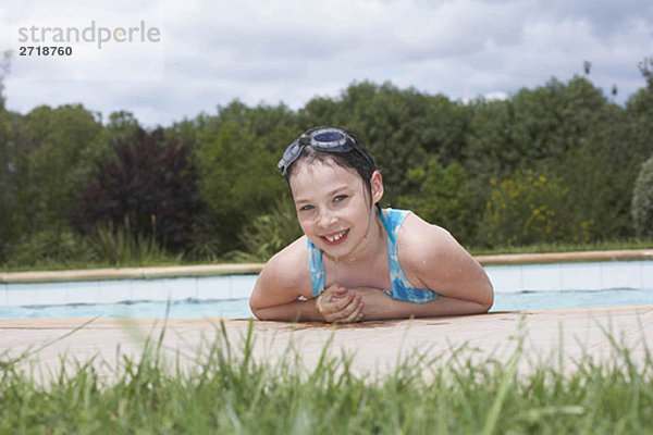 Junges Mädchen lächelt am Swimmingpool