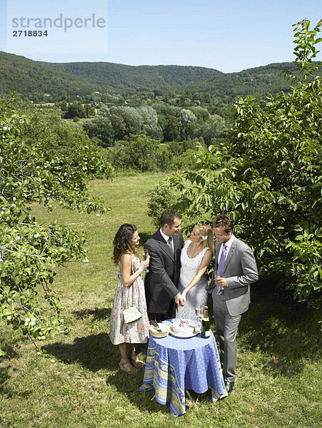 Hochzeitspaar beim Kuchenschneiden im Garten