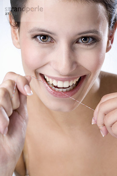 Junge Frau mit Zahnseide  Nahaufnahme
