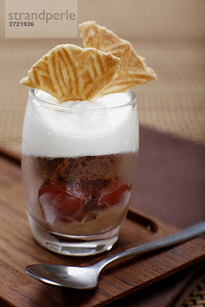 Chocolate ice cream with cherries  whipped cream and ice wafer