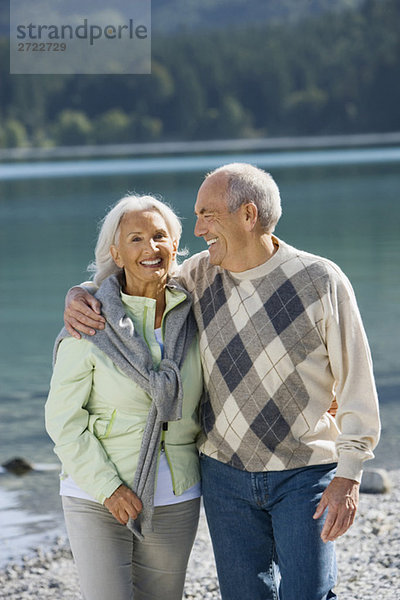 Deutschland  Bayern  Walchensee  Seniorenpaar am Seeufer  lächelnd