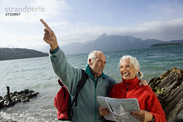 Senior couple with map  man pointing with finger