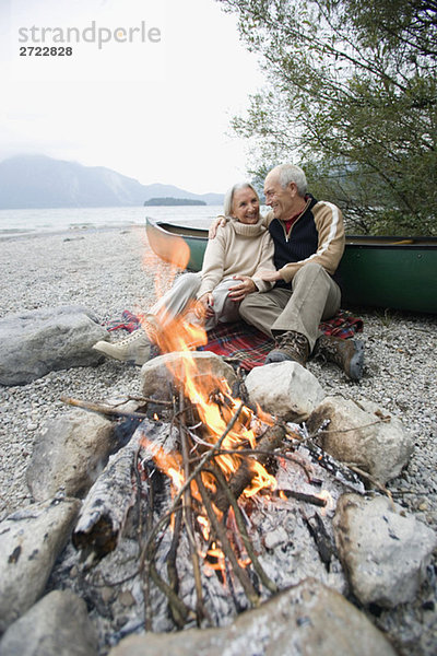 Germany  Bavaria  Walchensee  Senior couple sitting at campfire