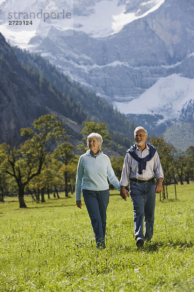 Österreich  Ahornboden  Seniorenpaar geht über die Wiese  Hand in Hand