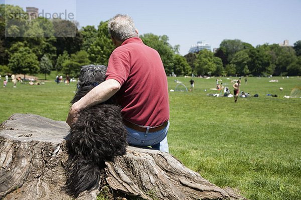 Ein Mann mit dem Arm um seinen Hund  Rückansicht  Prospect Park  Brooklyn  New York  USA
