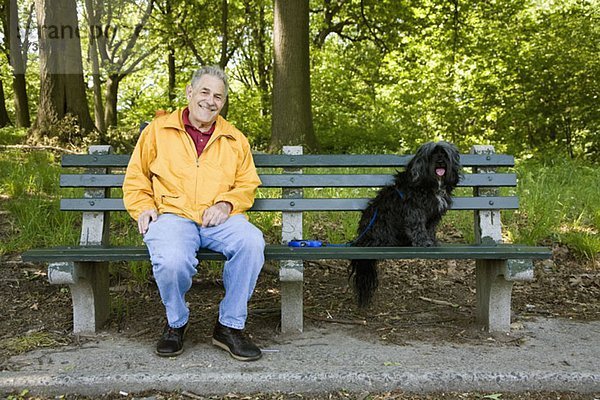 Ein Mann sitzt mit seinem Hund auf einer Parkbank  Prospect Park  Brooklyn  New York  USA