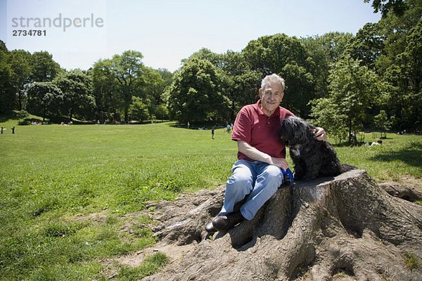 Ein Mann sitzt mit seinem Hund in einem Park  Prospect Park  Brooklyn  New York  USA