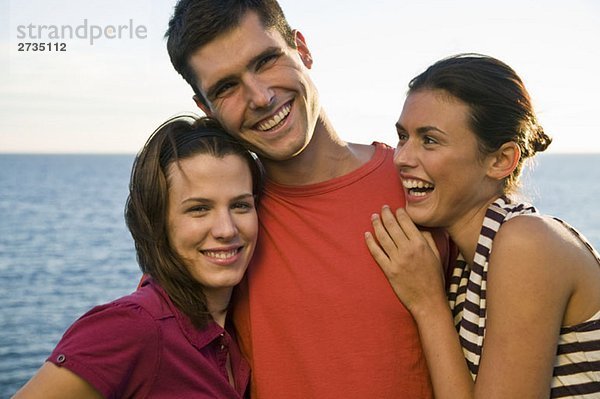 Drei Freunde beim Lachen am Meer