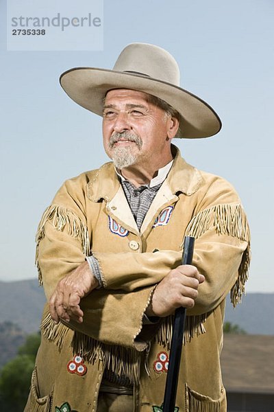 Porträt eines Cowboys  der mit seiner Waffe steht