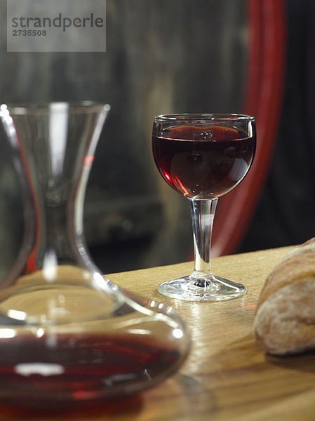 Ein Glas Rotwein  eine Karaffe Rotwein und ein Brot  Stilleben