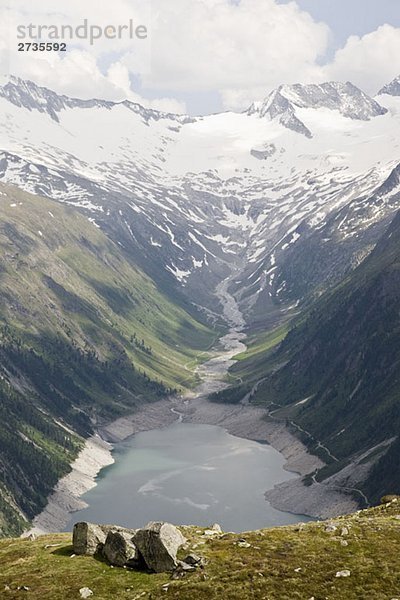 Blick auf ein Tal und Stausee in den österreichischen Alpen