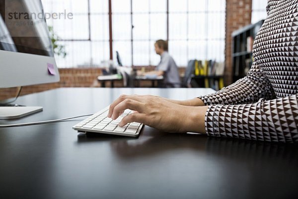 Eine Frau  die einen Computer in einem Büro benutzt.