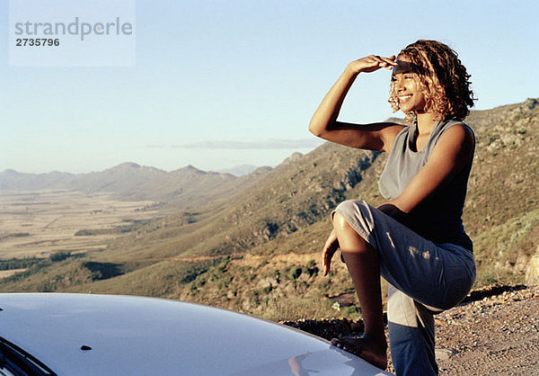 Eine junge Frau blickt durch eine trockene Landschaft