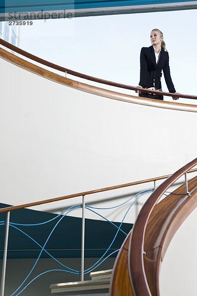Eine Geschäftsfrau  die oben auf einer Treppe steht.
