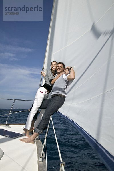 Ein Paar  das sich auf einer Yacht umarmt.