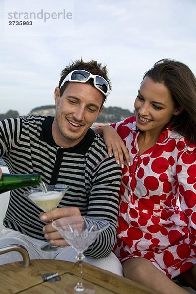 Ein Paar genießt Champagner auf einer Yacht