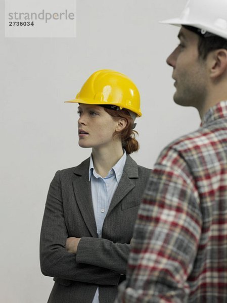 Ein Architekt im Gespräch mit einem Bauarbeiter