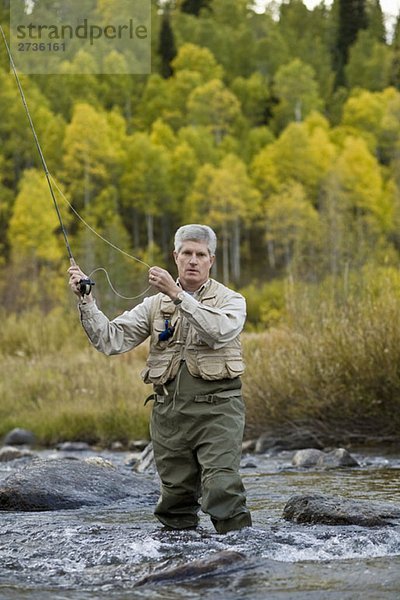 Ein Mann beim Fliegenfischen in einem Fluss