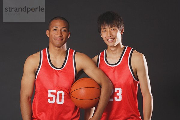 Lächelnd junge Männer posieren mit basketball
