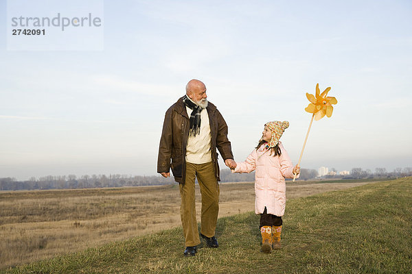 Mädchen hält Nadelrad mit ihrem Großvater
