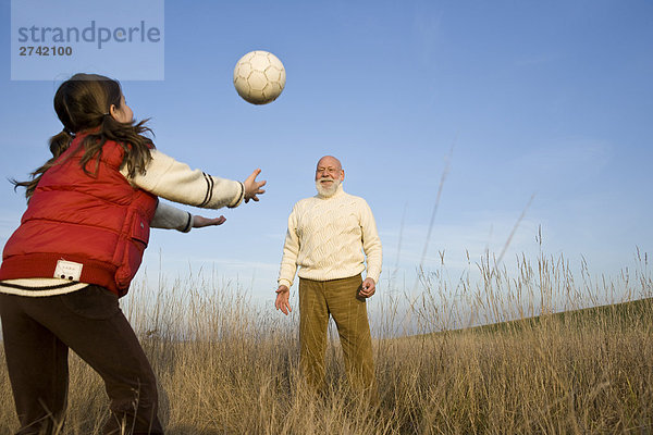 Mädchen Volleyballspielen mit ihrem Großvater