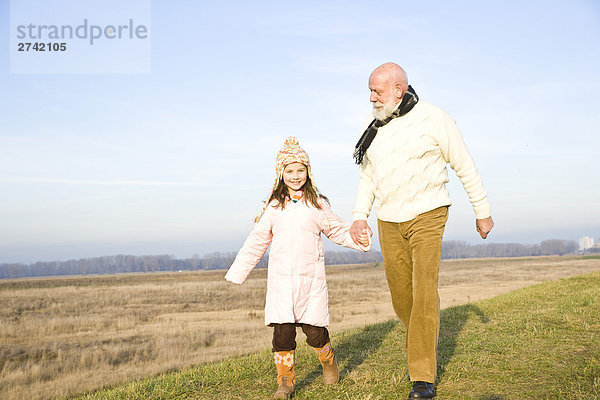 Mädchen mit ihrem Großvater zu Fuß