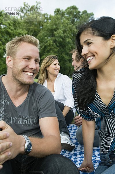 Männer und Frauen  die im Park sitzen