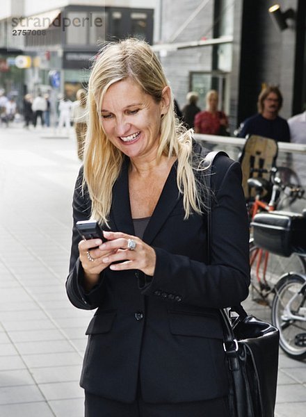 Glückliche Geschäftsfrau mit Handy