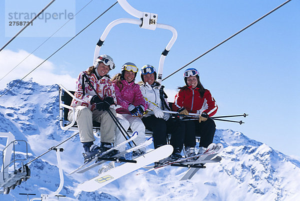 Vier Skifahrer im ein Sessellift Frankreich.