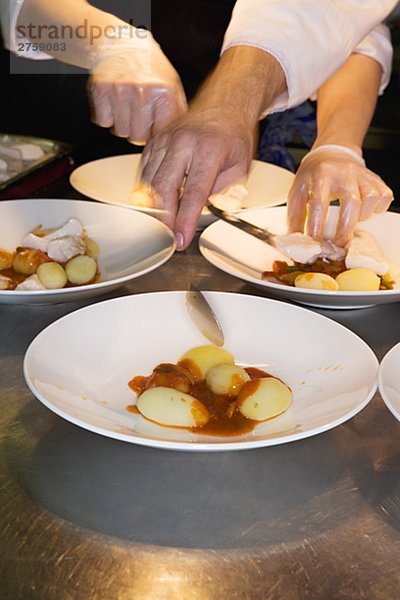 Ein Koch Essen in einem Restaurantküche Schweden zubereiten.