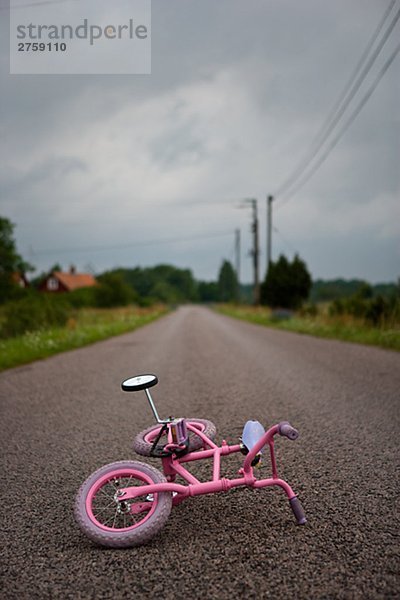 Ein rosa Fahrrad auf einem Oad Schweden liegen.