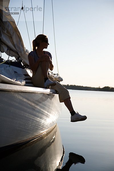 Eine Frau sitzt auf einem Segelboot Östergötlands Schweden.