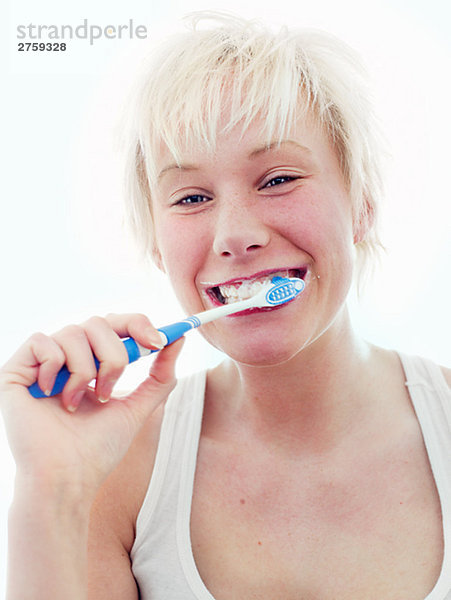 Eine skandinavische Teenagerin putzen ihre Zähne.