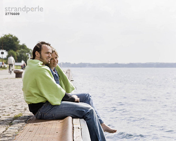 Mann und Frau starren auf einen See.