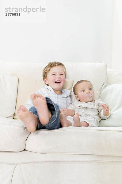 Brüder sitzen zusammen auf einem Sofa.