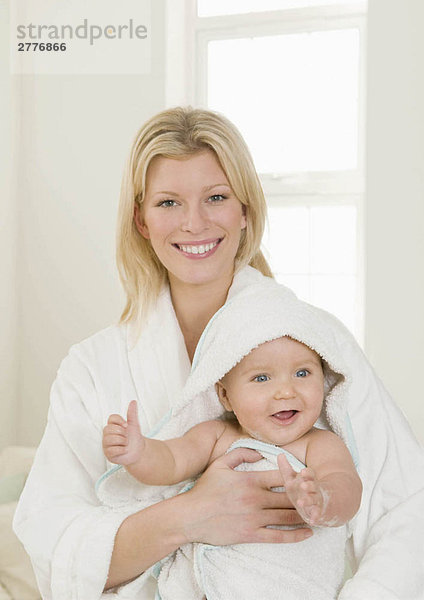 Eine Mutter hält ihr Baby in einem Handtuch.