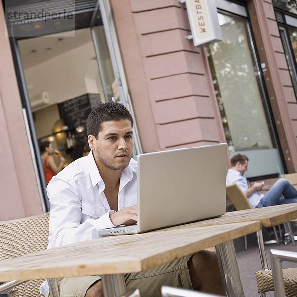 Mann draußen auf dem Laptop