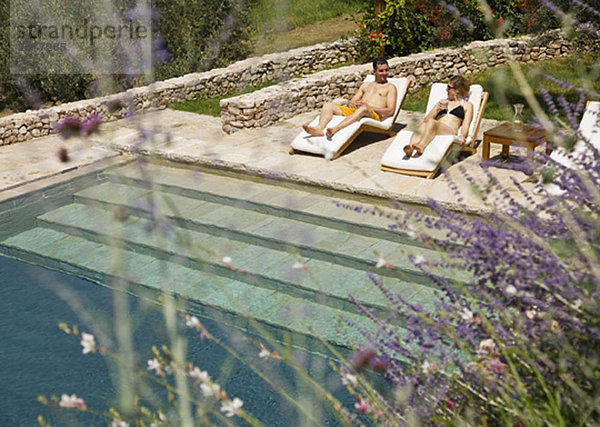 Mann und Frau entspannen am Pool