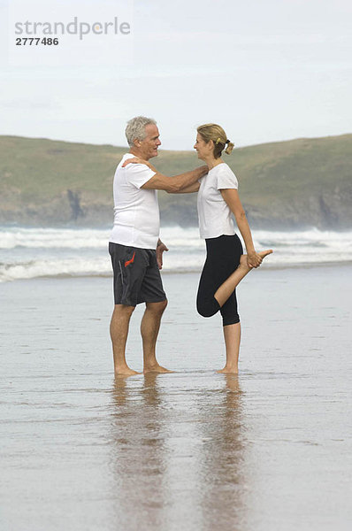 Paar Stretching am Strand