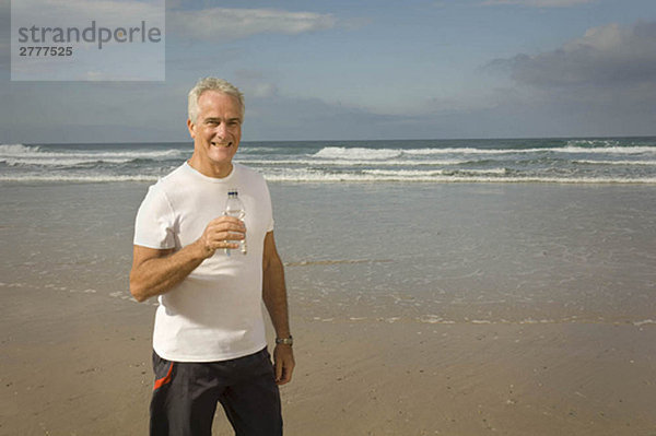 Männliches Trinkwasser am Strand