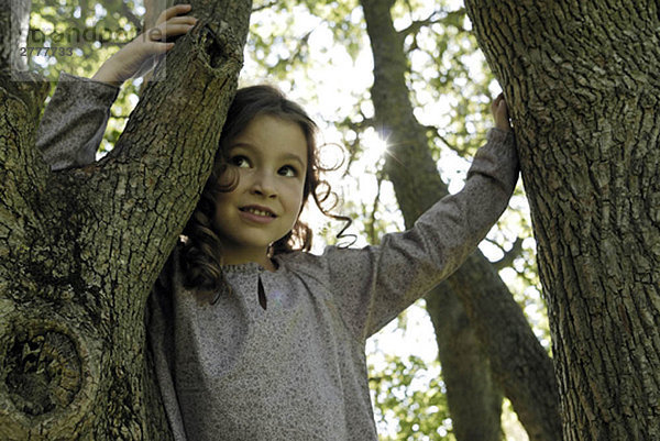 5 Jahre altes Mädchen an einem Baum stehend