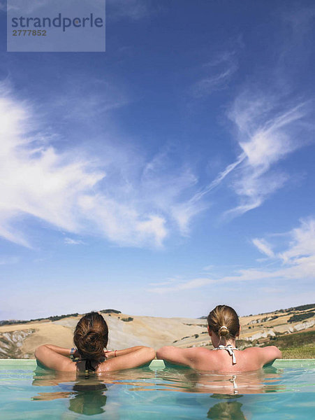 Frauen im Pool bewundern die Aussicht